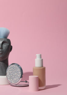 A collection of luxury lip care, makeup removal, and revitalizing serums on a pink backdrop, showcasing beauty essentials.