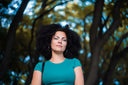 Confident woman with voluminous hair outdoors, representing holistic beauty and skincare essentials.